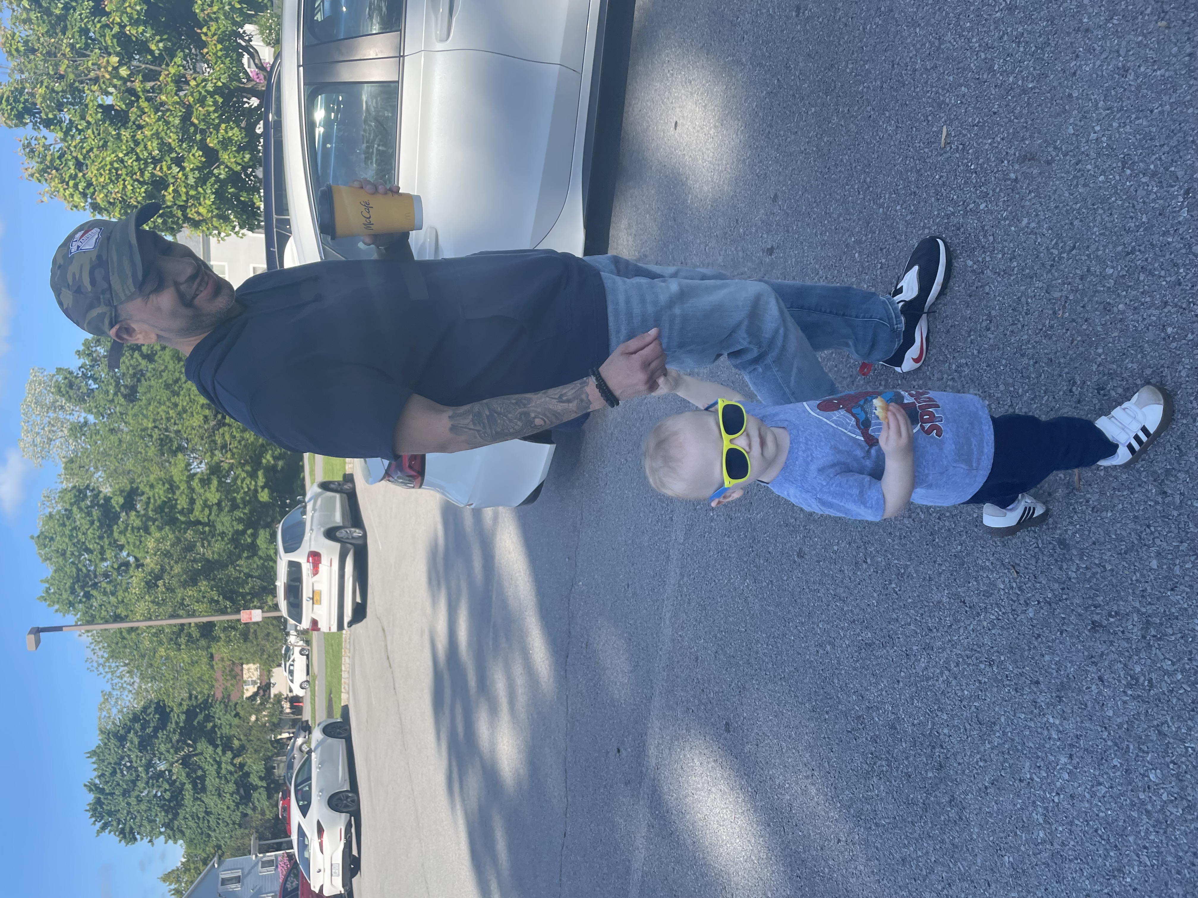 A picture of my son and I walking through a parking lot.